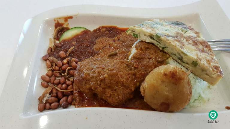 That's butter chicken and bergedil (fried potato patties) to complete a customer's meal of Nasi Lemak at PwC Cafeteria. Singapore